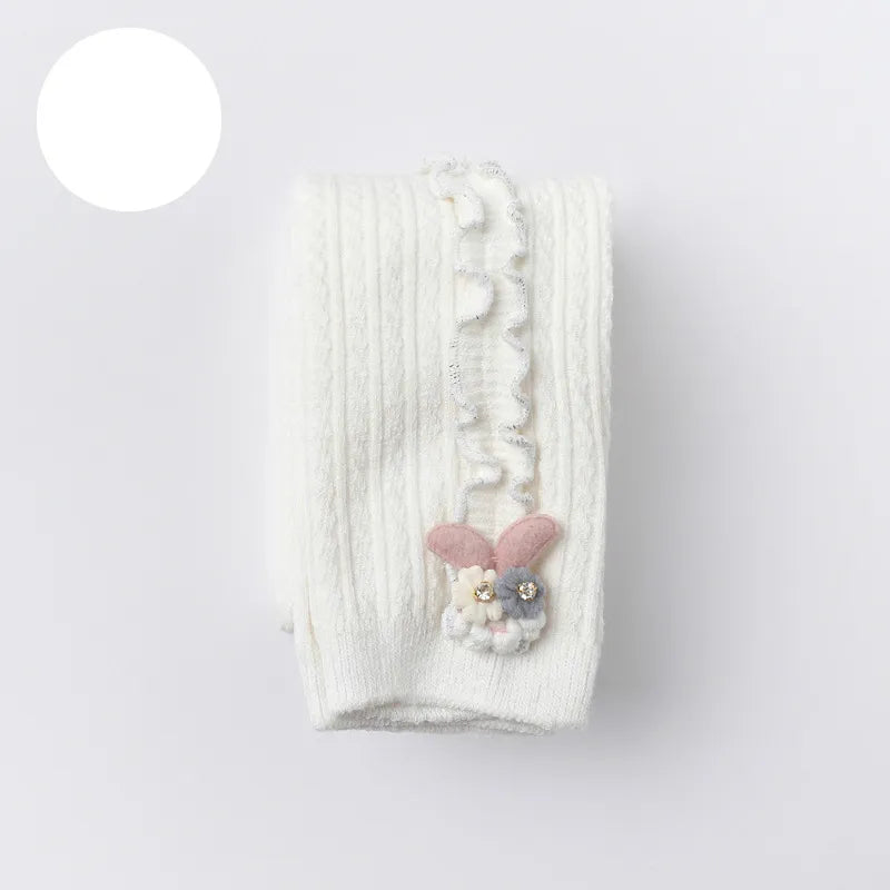 Baby girl fashion: ribbed cotton tights paired with a dress, for a stylish infant look.
