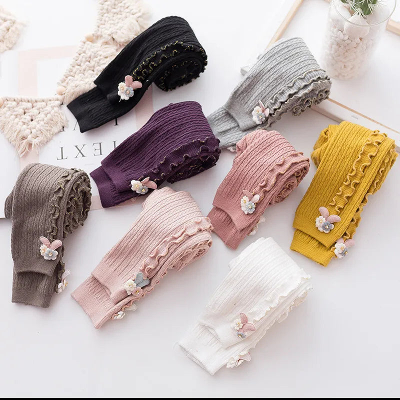 Assorted ribbed cotton tights neatly folded, ready for infant and toddler wardrobes.