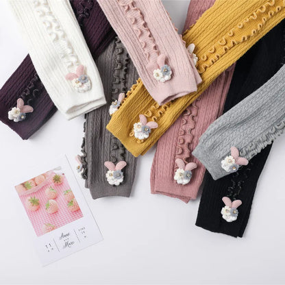 Stack of colorful ribbed cotton tights for toddlers and infants, essential baby girl fashion.