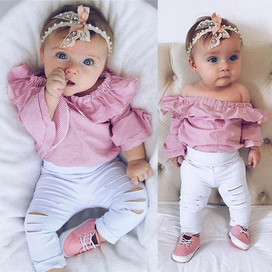 Baby girl wearing striped Bardot top with ruffled sleeves and ripped jeans, infant summer fashion set
