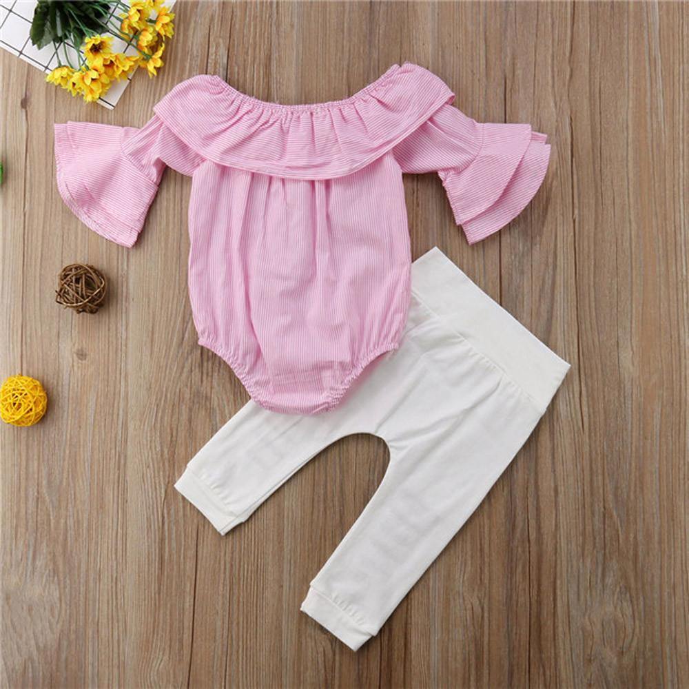 Adorable baby girl modeling a summer outfit with a striped Bardot top and comfy ripped pants
