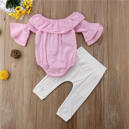 Adorable baby girl modeling a summer outfit with a striped Bardot top and comfy ripped pants