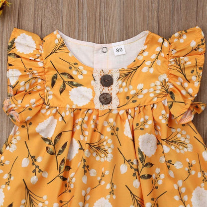 Close-up of a baby girl yellow floral sleeveless frock, showcasing the delicate frill details.