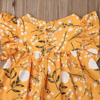 Full shot of a baby girl in a cute yellow floral frill sleeveless dress, a lovely kids outfit.