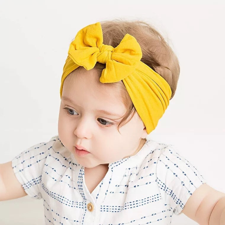 Toddler girl wearing blue soft elastic headband with bow, comfortable baby hair accessory