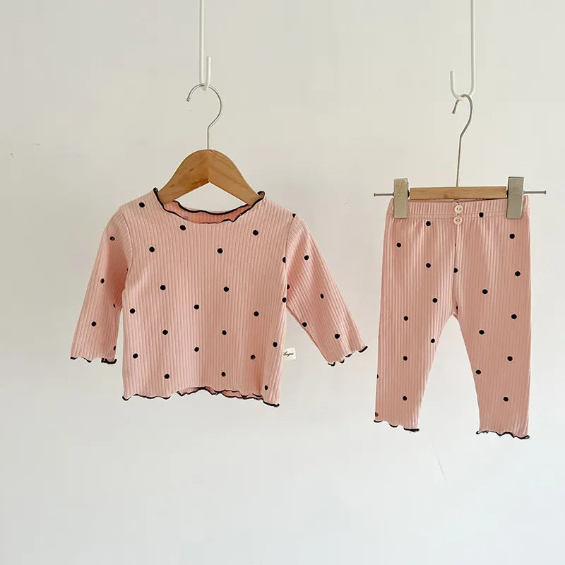 Folded baby girl's dot print cotton sleeper set, ready for gifting or everyday use