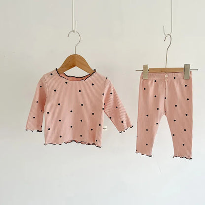 Folded baby girl's dot print cotton sleeper set, ready for gifting or everyday use