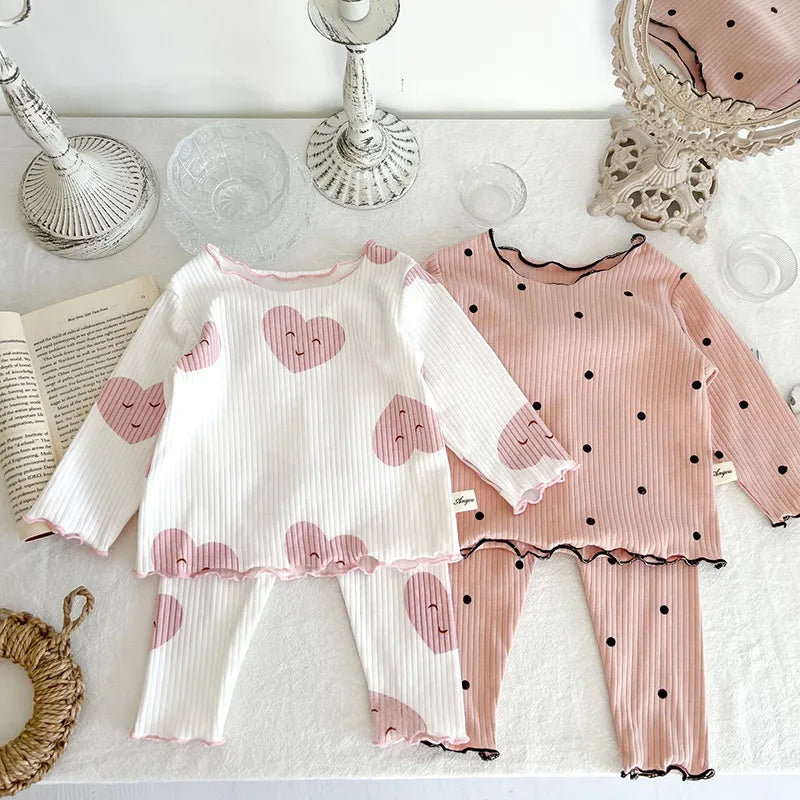 Full view of baby girl wearing a comfortable dot print cotton sleeper set, ideal for indoor play