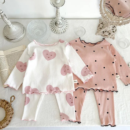 Full view of baby girl wearing a comfortable dot print cotton sleeper set, ideal for indoor play