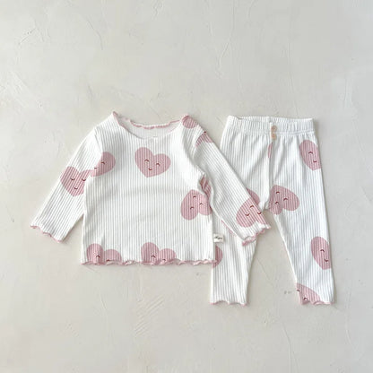 Soft pink cotton sleeper set for baby girls, featuring a charming white dot print design