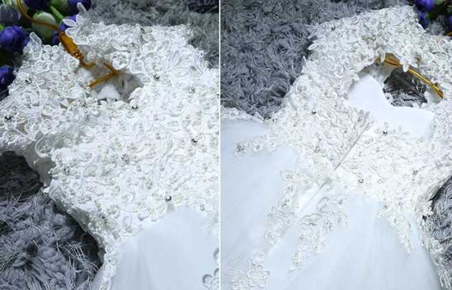 Close-up of a baby's white lace sequin ball gown, ideal for christening or formal events