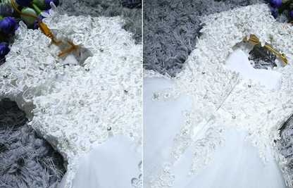 Close-up of a baby's white lace sequin ball gown, ideal for christening or formal events
