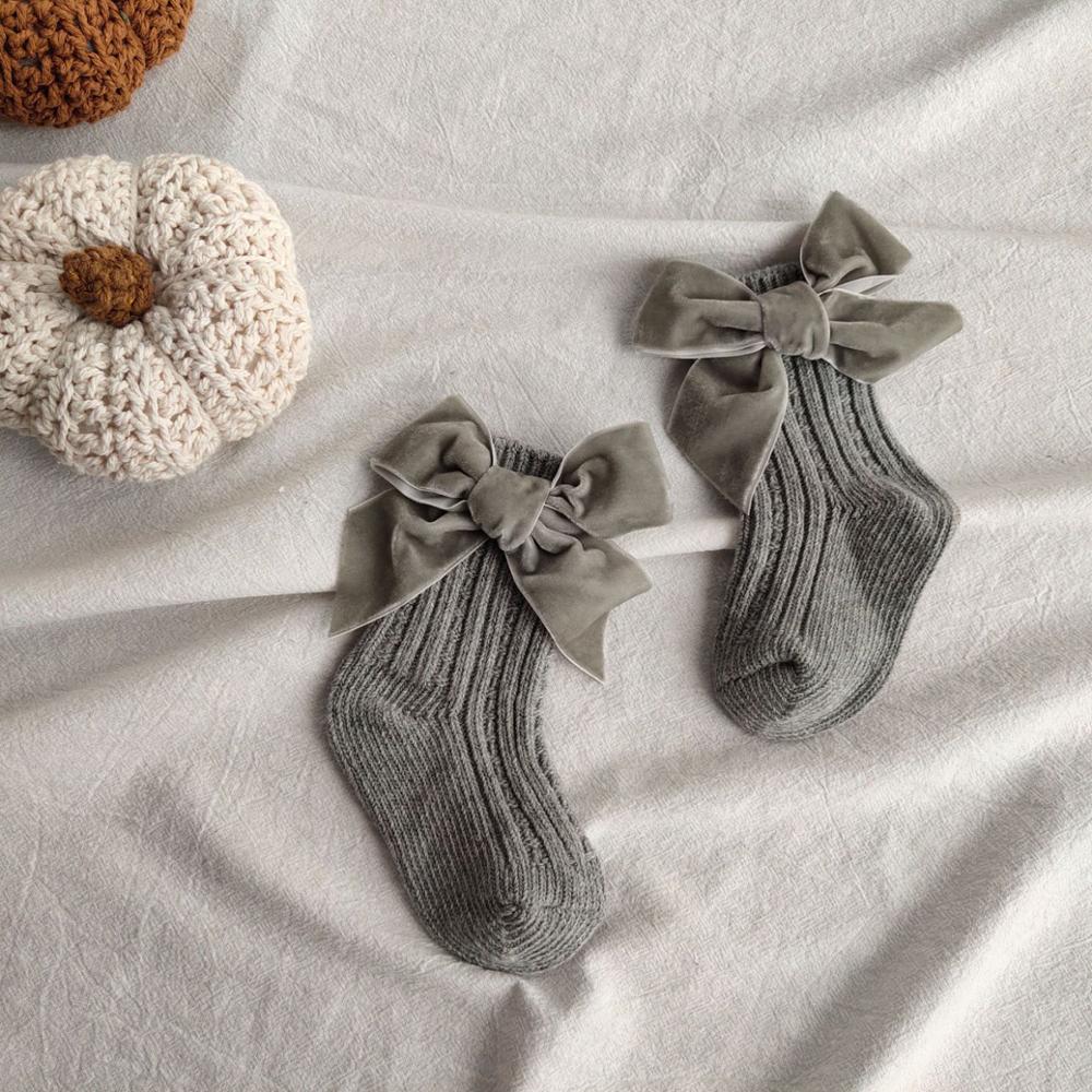 Pair of warm baby girl ankle socks, big cream bows, soft cotton, comfortable for toddlers, stylish infant wear.