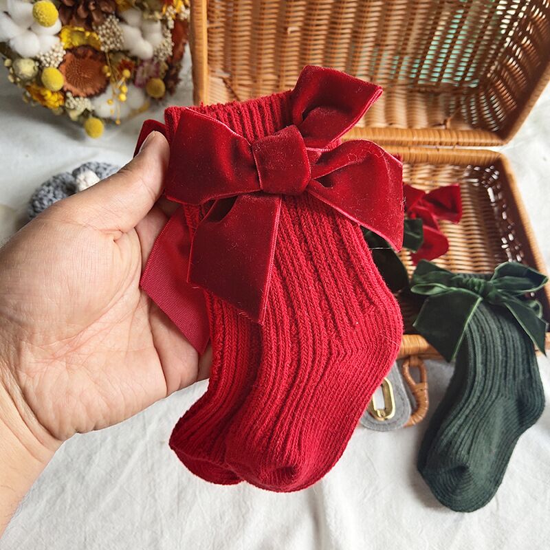 Baby girl's ankle socks with a large red bow, comfortable and warm, soft cotton for sensitive skin, cute infant accessory.