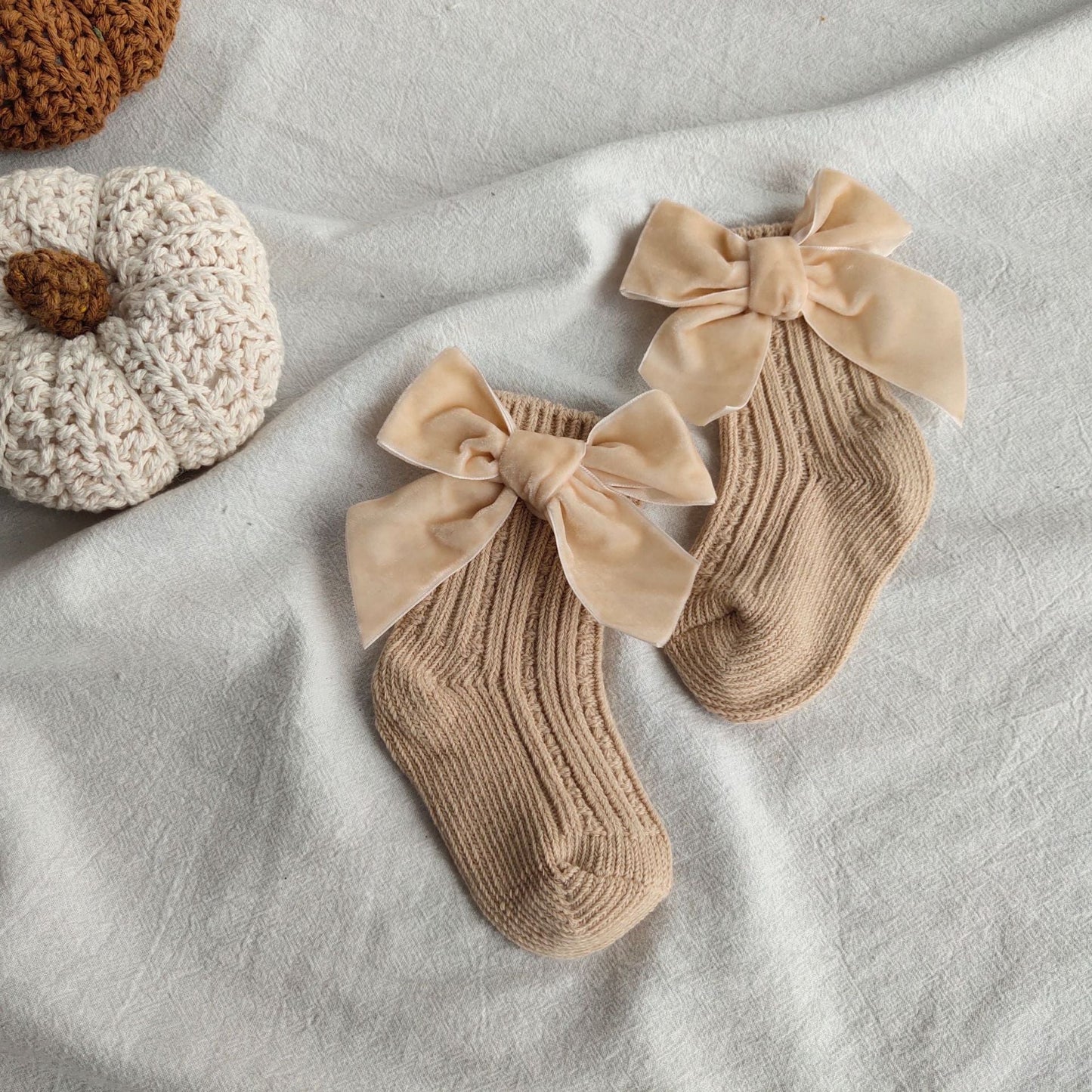 Detail shot of a baby girls' warm ankle sock, purple bow, ribbed cuff, stretchable cotton, ideal for growing infants.