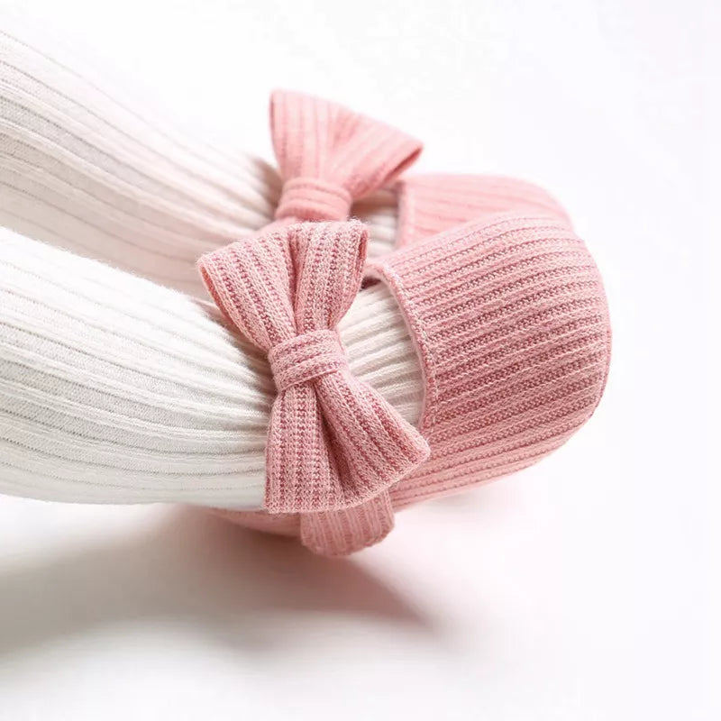 Baby girls pink anti-slip sneakers with a large decorative bow, soft sole for infants.