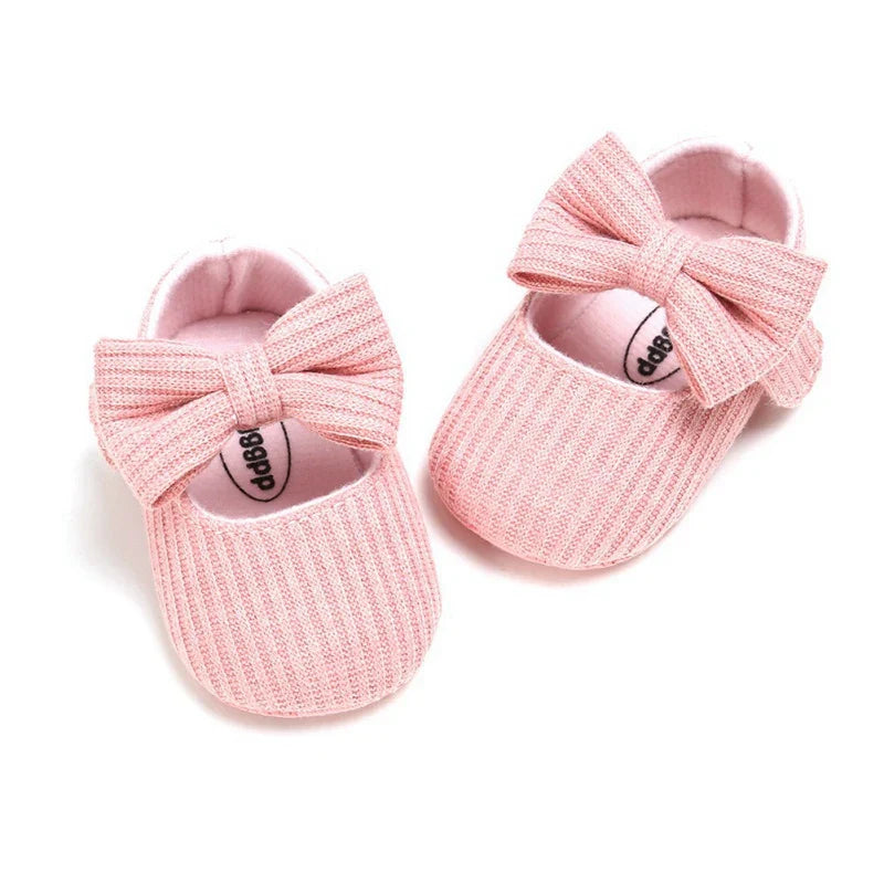 White baby girl shoes, anti-slip soft sole sneakers with a delicate floral bow.