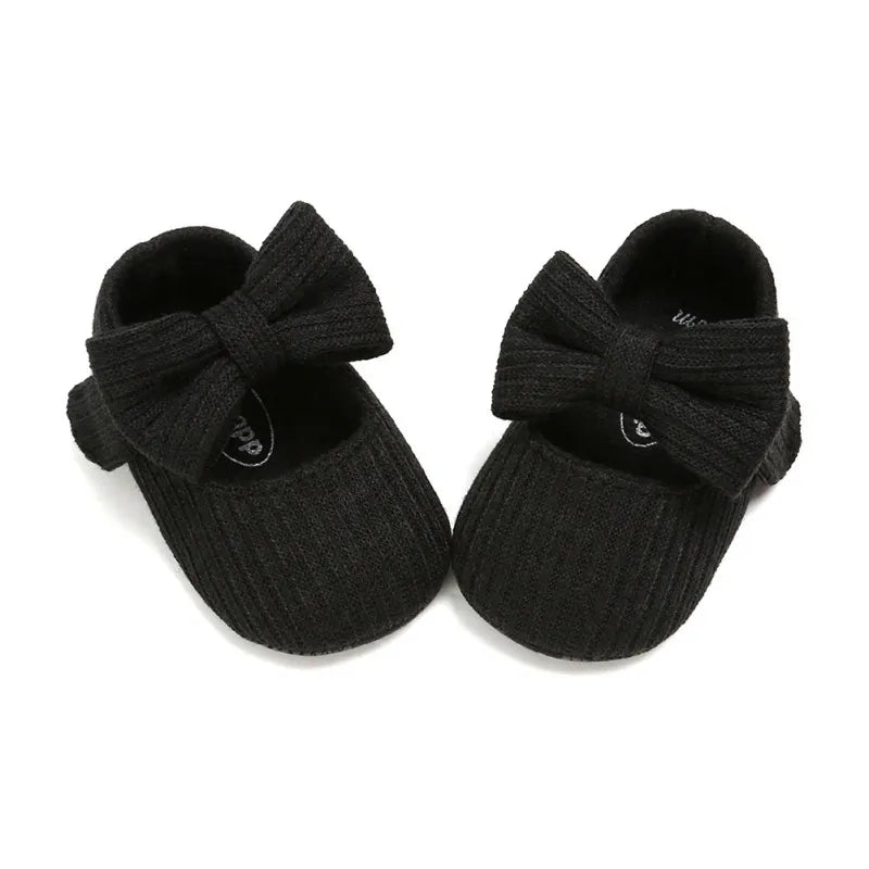 White baby girl anti-slip sneakers with a double bow detail and a soft, flexible sole.
