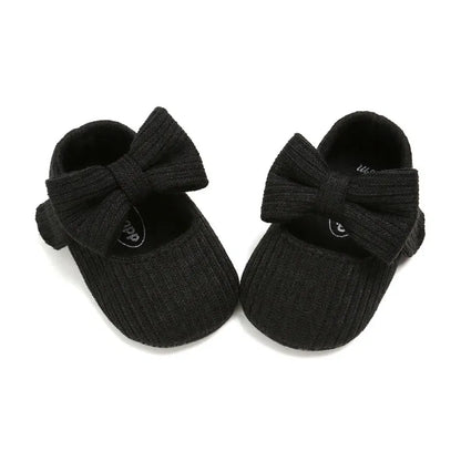 White baby girl anti-slip sneakers with a double bow detail and a soft, flexible sole.