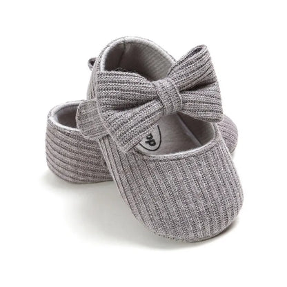 Infant girl's navy anti-slip sneakers featuring a cute bow, flexible soft sole design.
