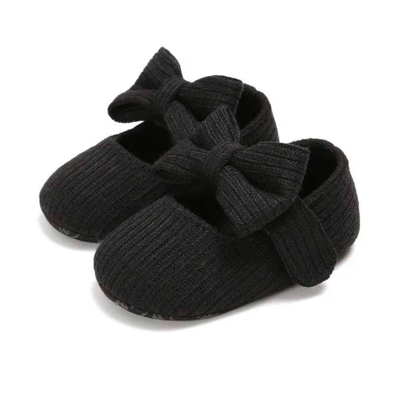 Light blue infant anti-slip sneakers with a prominent bow, designed with a soft sole.