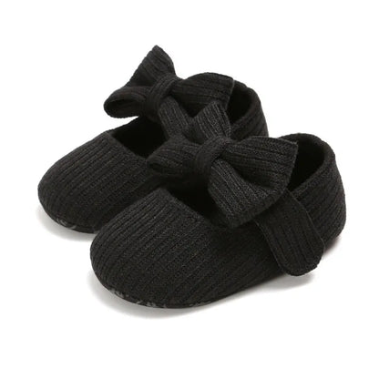 Light blue infant anti-slip sneakers with a prominent bow, designed with a soft sole.
