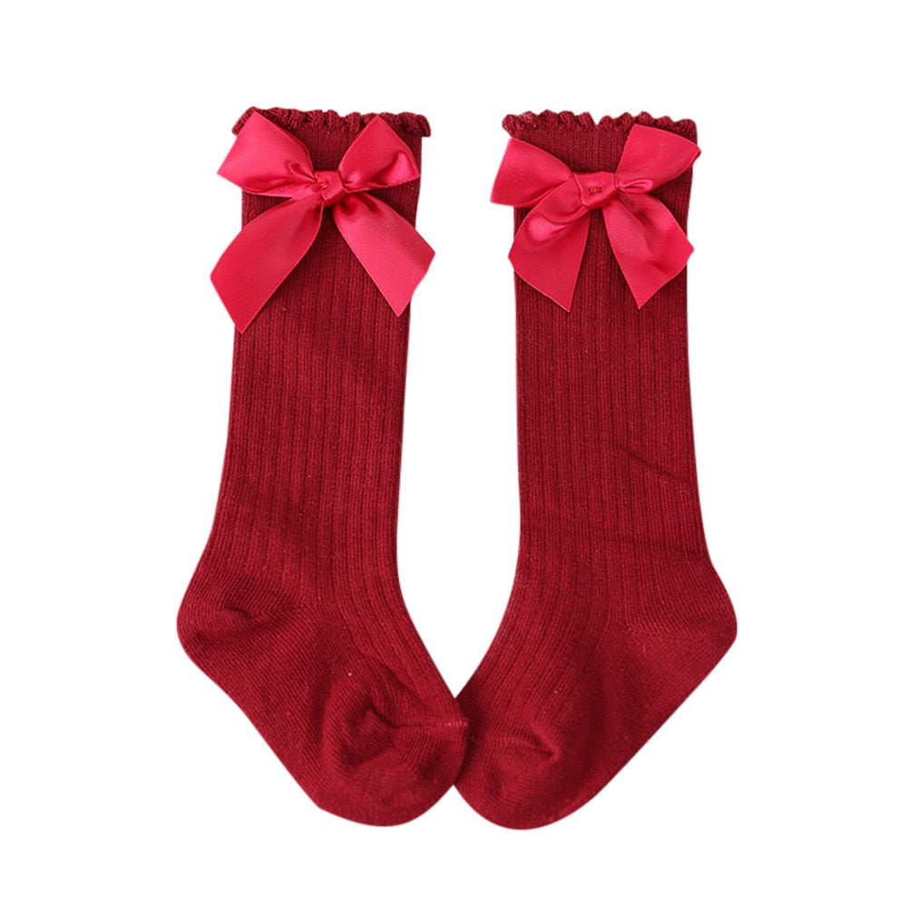 Infant apparel: cozy white cotton knee-high socks for baby girls with bow