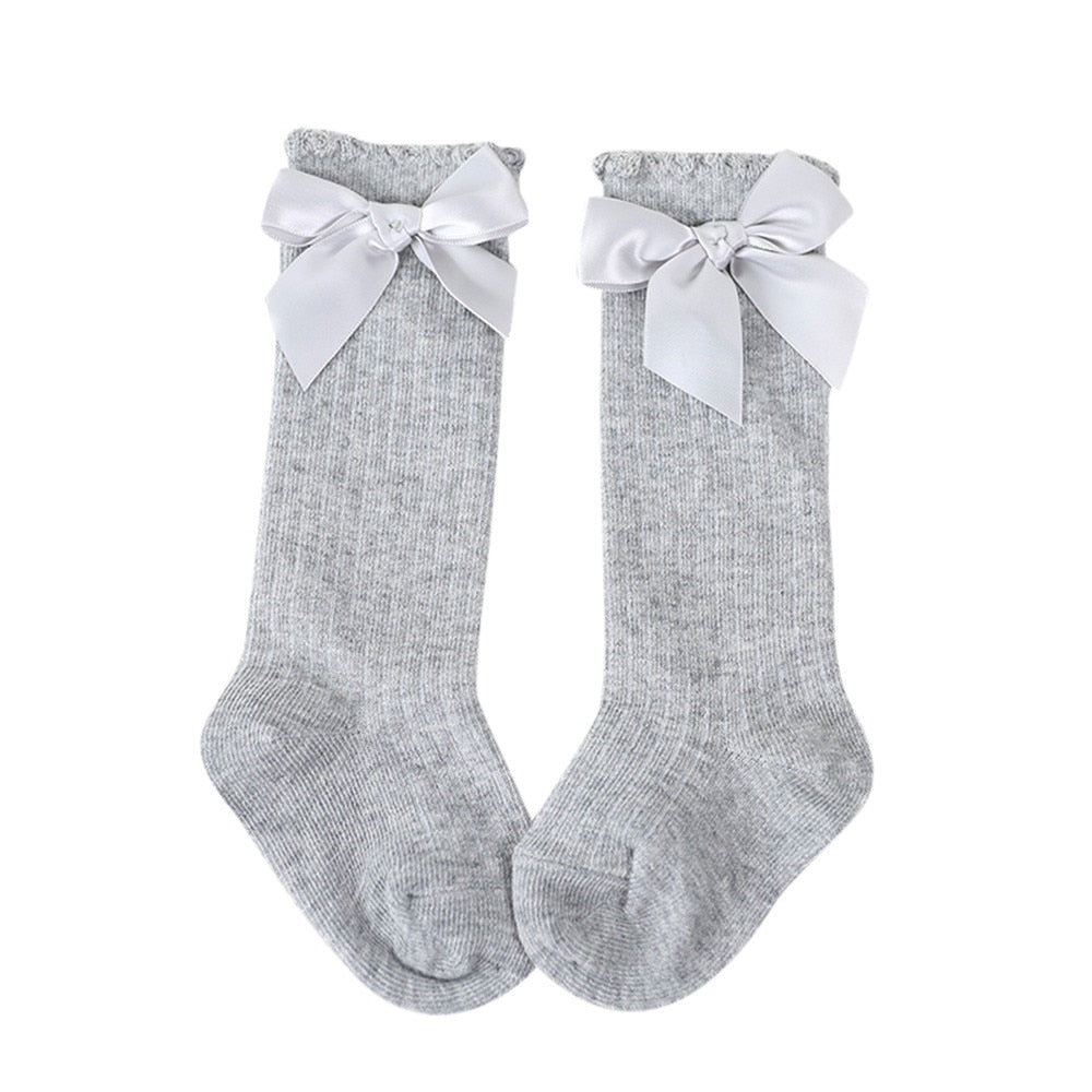 Classic white baby girls' knee-high socks, soft cotton with a sweet bow