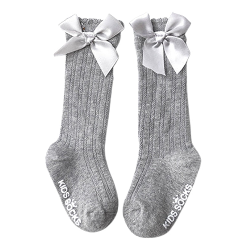 Infant fashion: essential white cotton knee-high socks with a cute bow