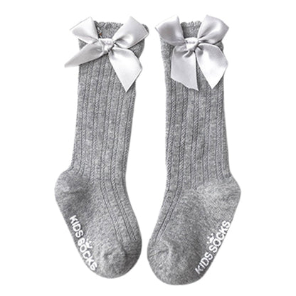 Infant fashion: essential white cotton knee-high socks with a cute bow