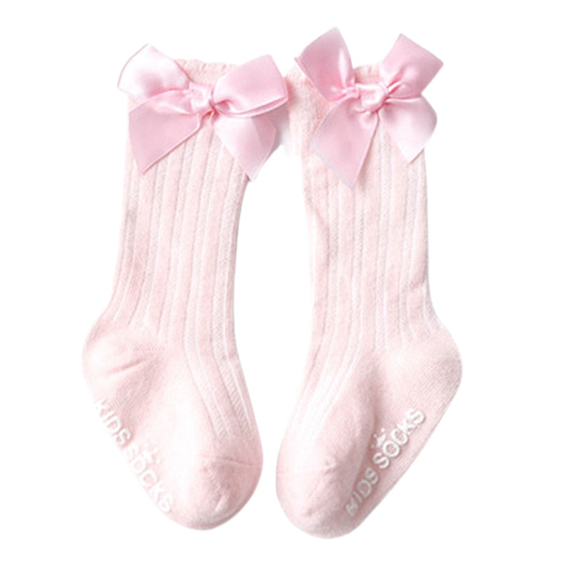 Close-up of a baby girls' knee-high sock, showing the soft cotton and bowknot