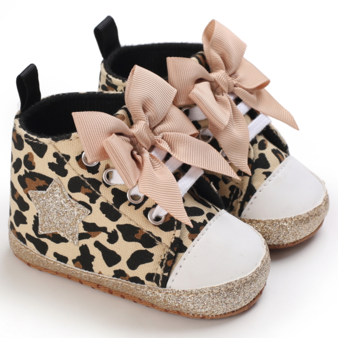 Pair of baby girls' pink hi-top sneakers designed for first steps, with decorative bows