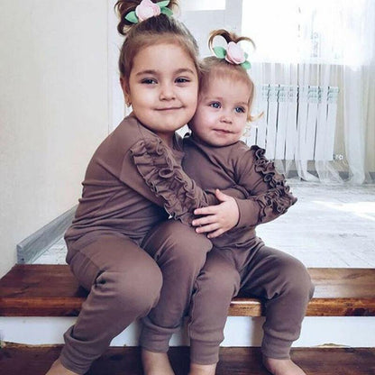 Stylish baby girl in a pink cotton sweatshirt and complementing pants, essential toddler fashion