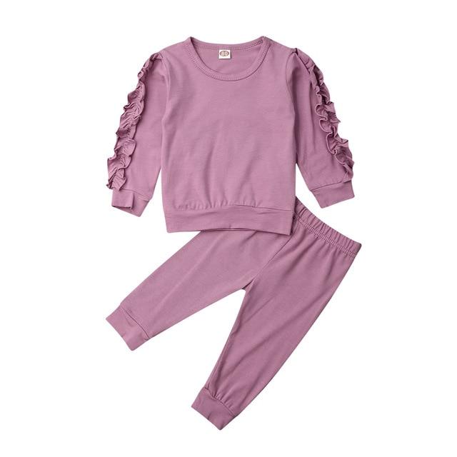Adorably styled baby girl in a complete cotton sweatshirt and pants set for winter
