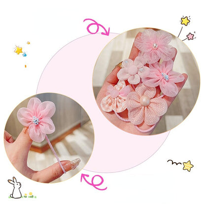 Close-up of a baby girl's plain pink elastic hair tie, included in a larger accessory set