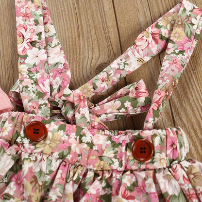 Close-up of a baby girls' floral ruffled romper with intricate print details. Soft baby outfit.