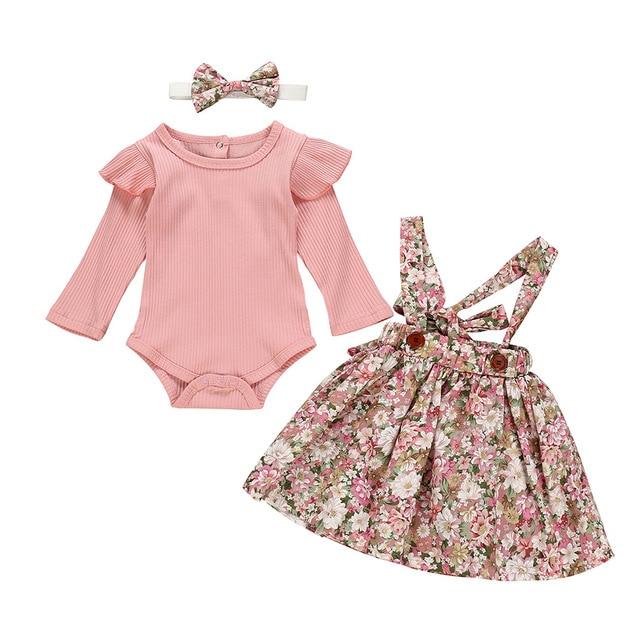Full view of a baby girls' floral romper and skirt set, showcasing ruffled sleeves. Baby fashion.