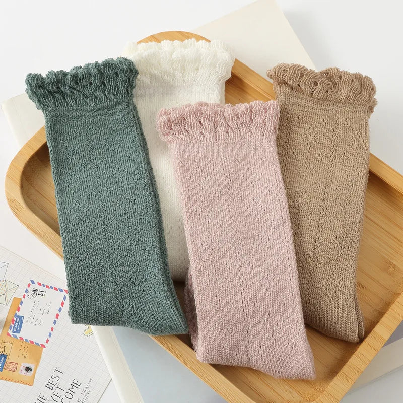 Close-up of hollow knit texture on baby girls' knee-high socks, soft & breathable for summer