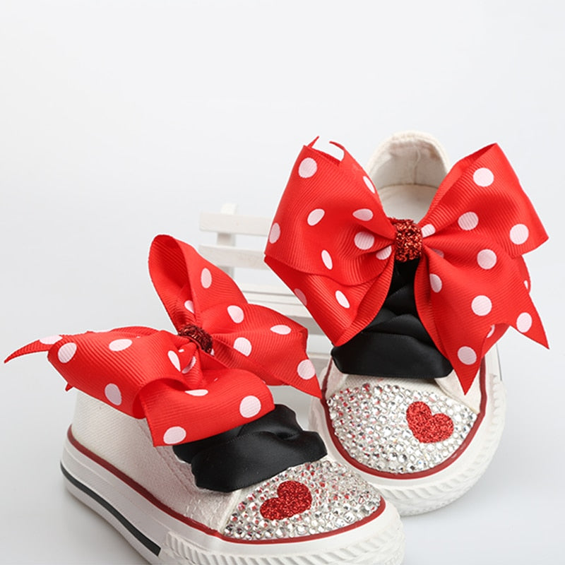 Stylish baby girls' footwear: white canvas polka dot shoes accented with a charming bowknot.