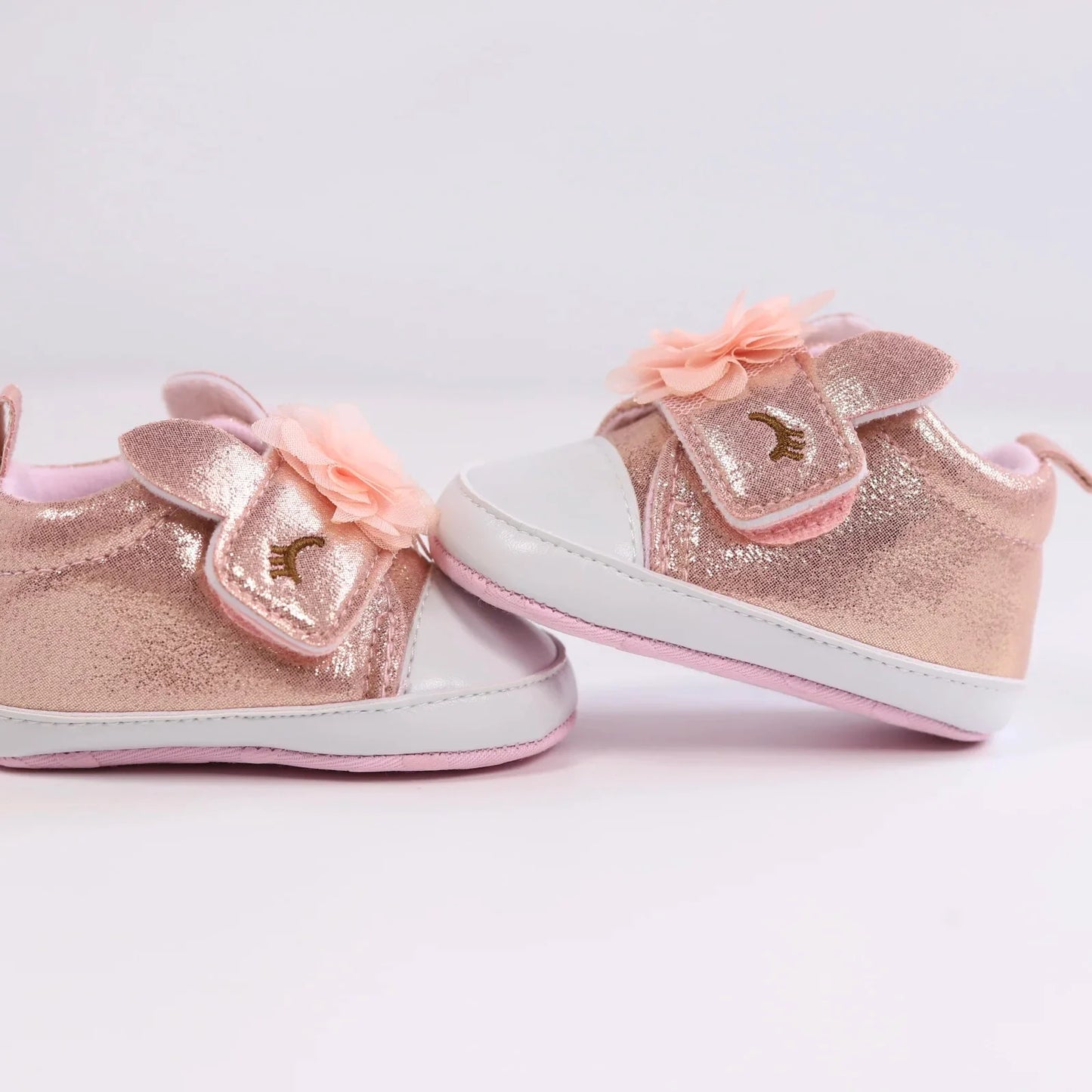 Pink unicorn baby shoes designed as first walkers, promoting healthy foot development.
