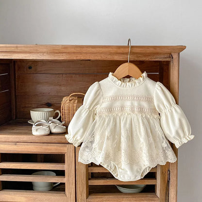 Baby girls' pink waffle knit bodysuit with puff sleeves and delicate lace trim, 100% cotton.