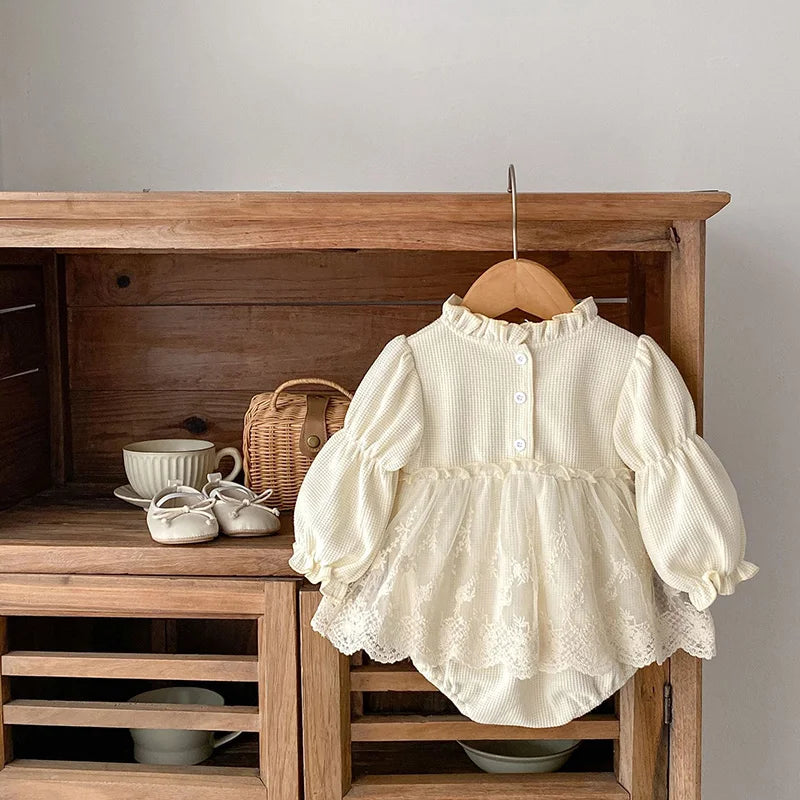 Pink baby girls' bodysuit, waffle knit cotton, with stylish puff sleeves and intricate lace trim.