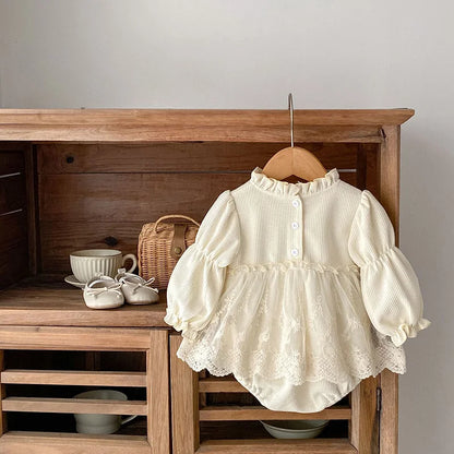 Pink baby girls' bodysuit, waffle knit cotton, with stylish puff sleeves and intricate lace trim.