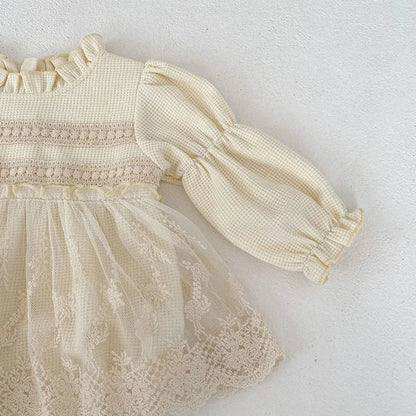 Studio shot of a pink waffle knit baby girls' bodysuit, showcasing puff sleeves and lace details.