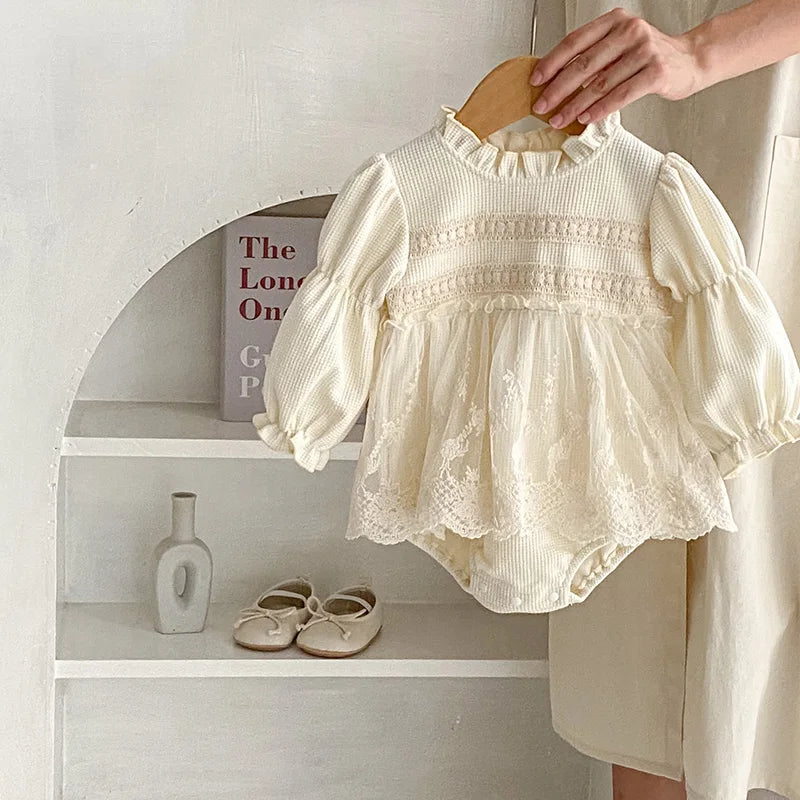 Soft cotton baby girls' bodysuit featuring a waffle texture, puff sleeves and elegant lace trim.