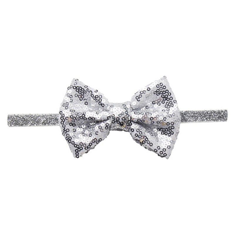 Close-up of the textured sequin bow on a baby headband, high-quality, dazzling pink color