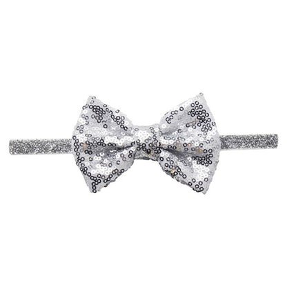 Close-up of the textured sequin bow on a baby headband, high-quality, dazzling pink color