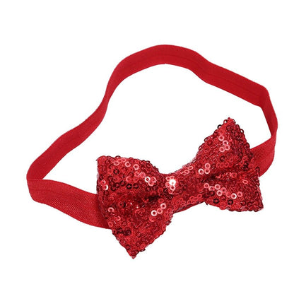 Close-up of a baby's sequin bow headband, sparkling pink glitter, comfortable and stylish infant accessory