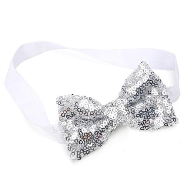 Detail of the glittery sequin bow on a baby girl's headband, perfect party accessory