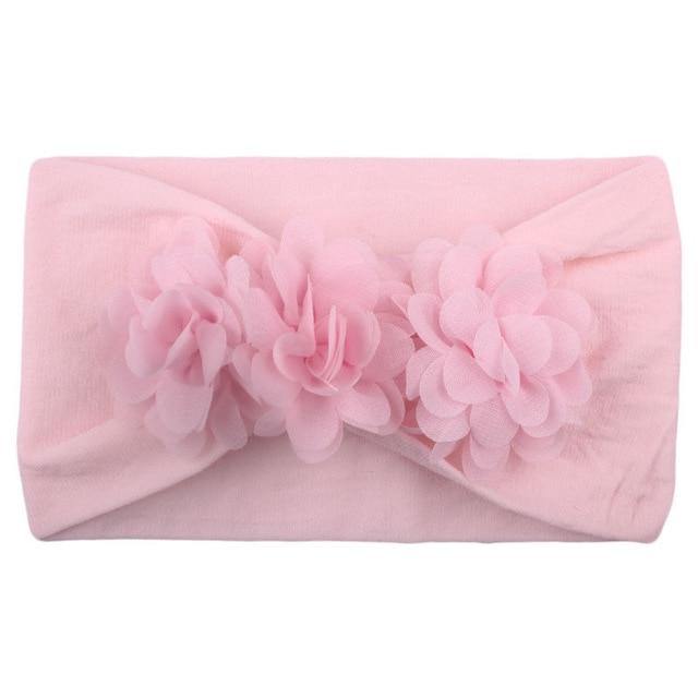 Soft yellow flower elastic headband designed for a baby girl, a comfortable infant accessory.